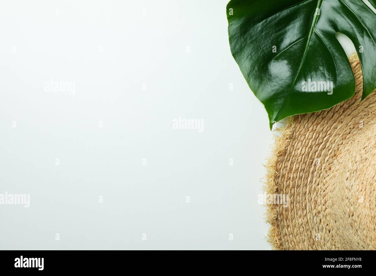 Straw hat and palm leaf on white background Stock Photo - Alamy