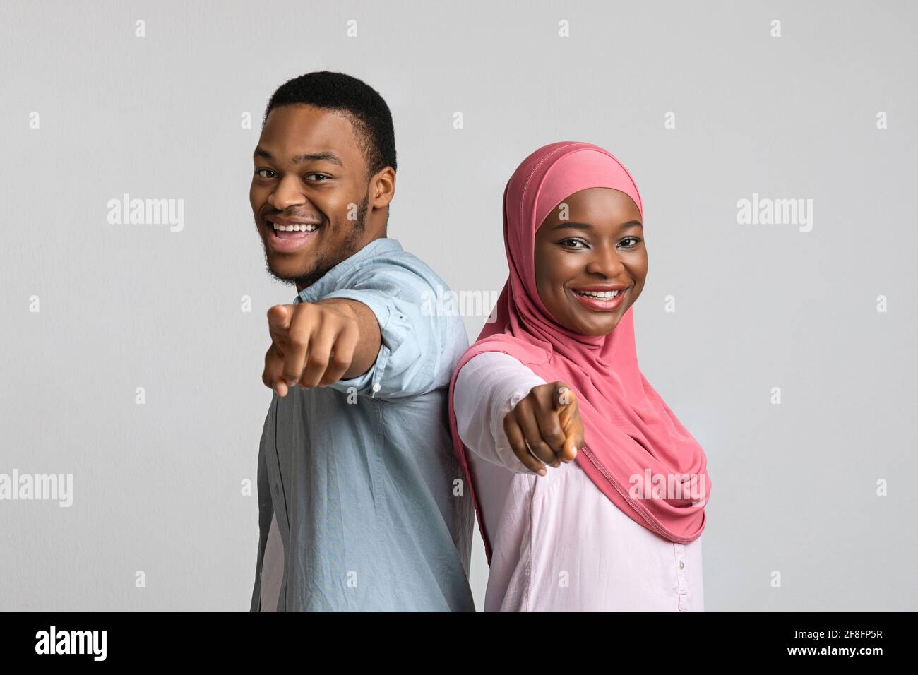Happy african american couple pointing at camera Stock Photo - Alamy