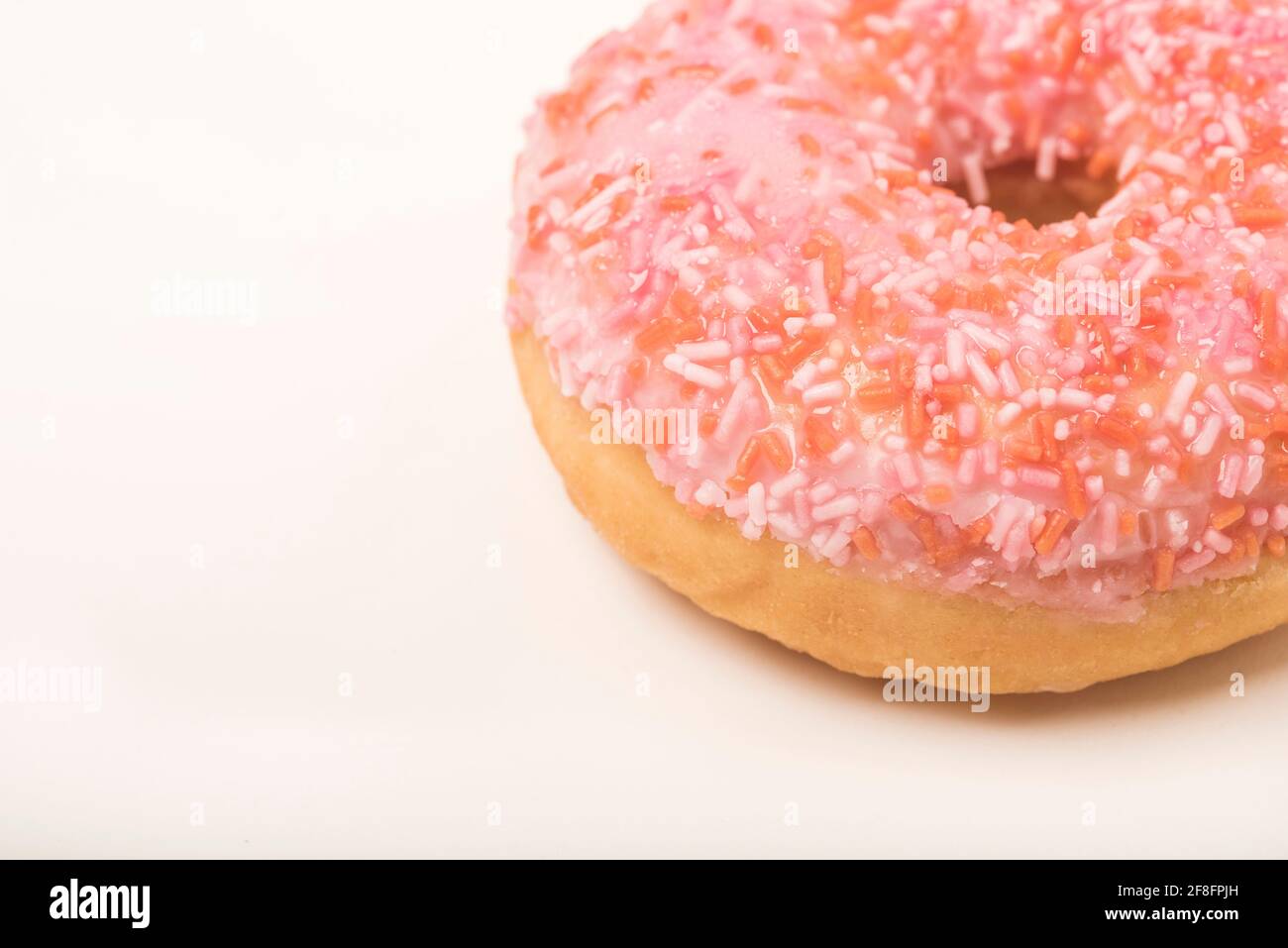 Close up of a colourful iced ring doughnut with sprinkles Stock Photo