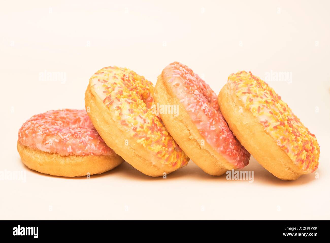 Colourful iced ring doughnuts with sprinkles. Stock Photo