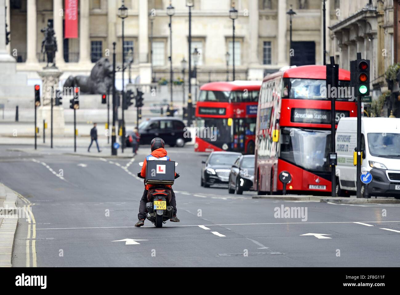London, England, UK. Learner motorbike delivery driver in Whitehall, heading towards Trafalgar Square Stock Photo