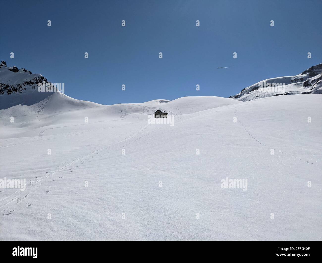 old customs hut between the austrian and swiss border on the plasseggenpass. Sunny ski tour in the mountains. blue sky Stock Photo