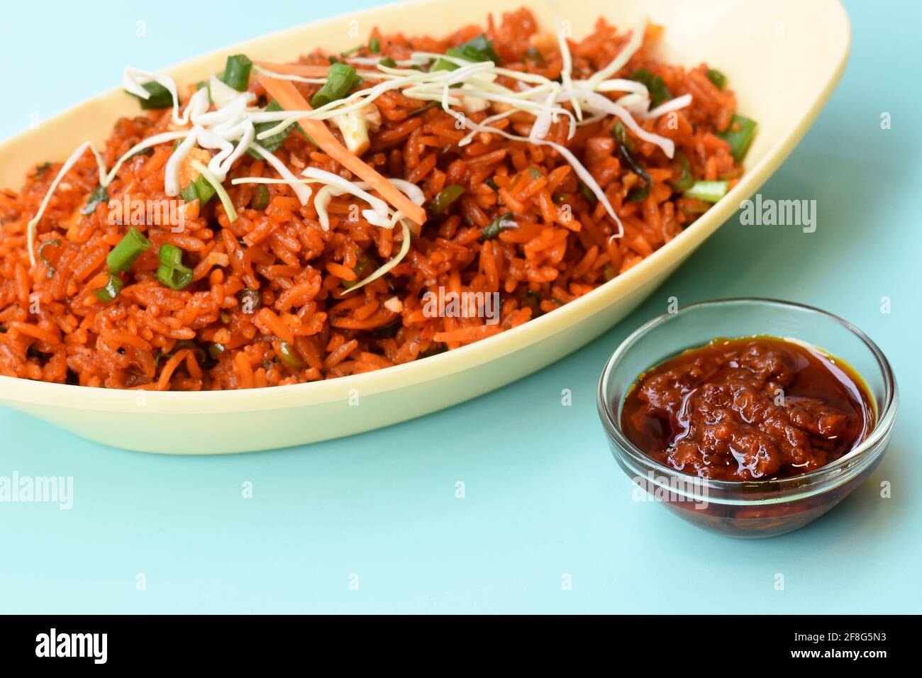 Schezwan fried rice with schezwan sauce, Chinese fried rice, garnished with spring onion and cabbage indo chinese cuisine dishes Stock Photo
