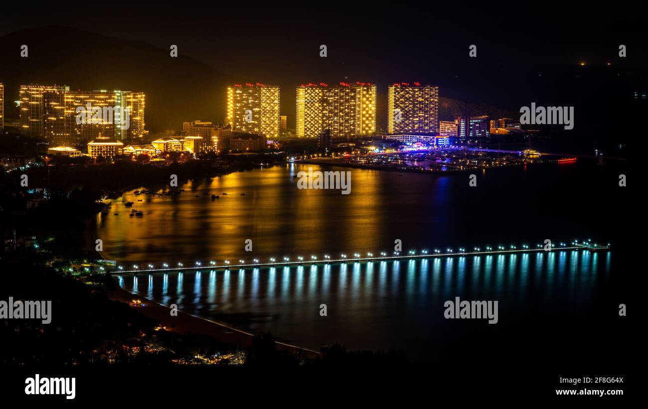 Sanya scenic nightscape with long pontoon in Sanya Bay and Banshan peninsula view in Sanya Hainan island China Stock Photo
