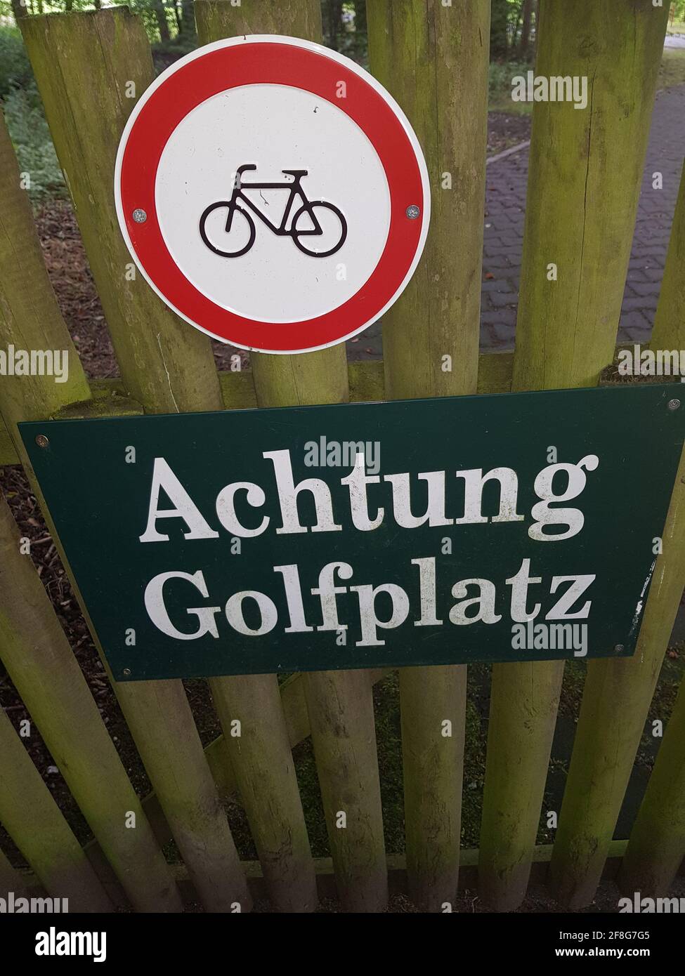 Rotes Verbotschild für Fahrräder verboten mit Beschriftung in Deutsch Achtung Golfplatz  Red prohibition sign for bicycles prohibited with inscription Stock Photo
