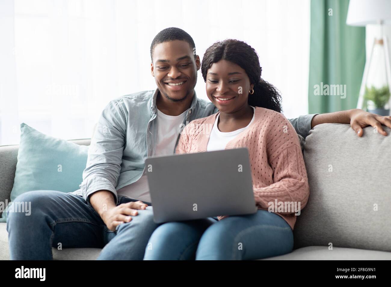 Happy african american family sitting on couch, using laptop Stock ...