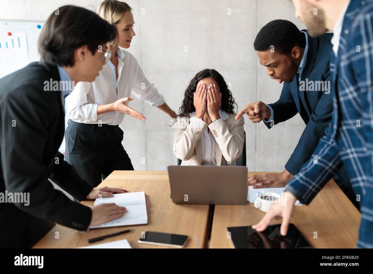 Displeased Business People Shouting At Unhappy Female Employee In Office Stock Photo