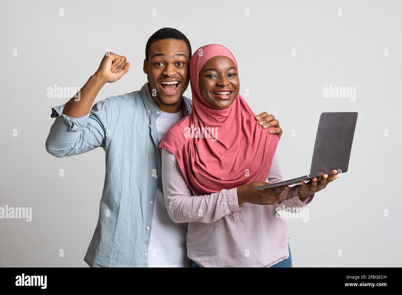 Excited african american muslim couple winners with laptop Stock Photo