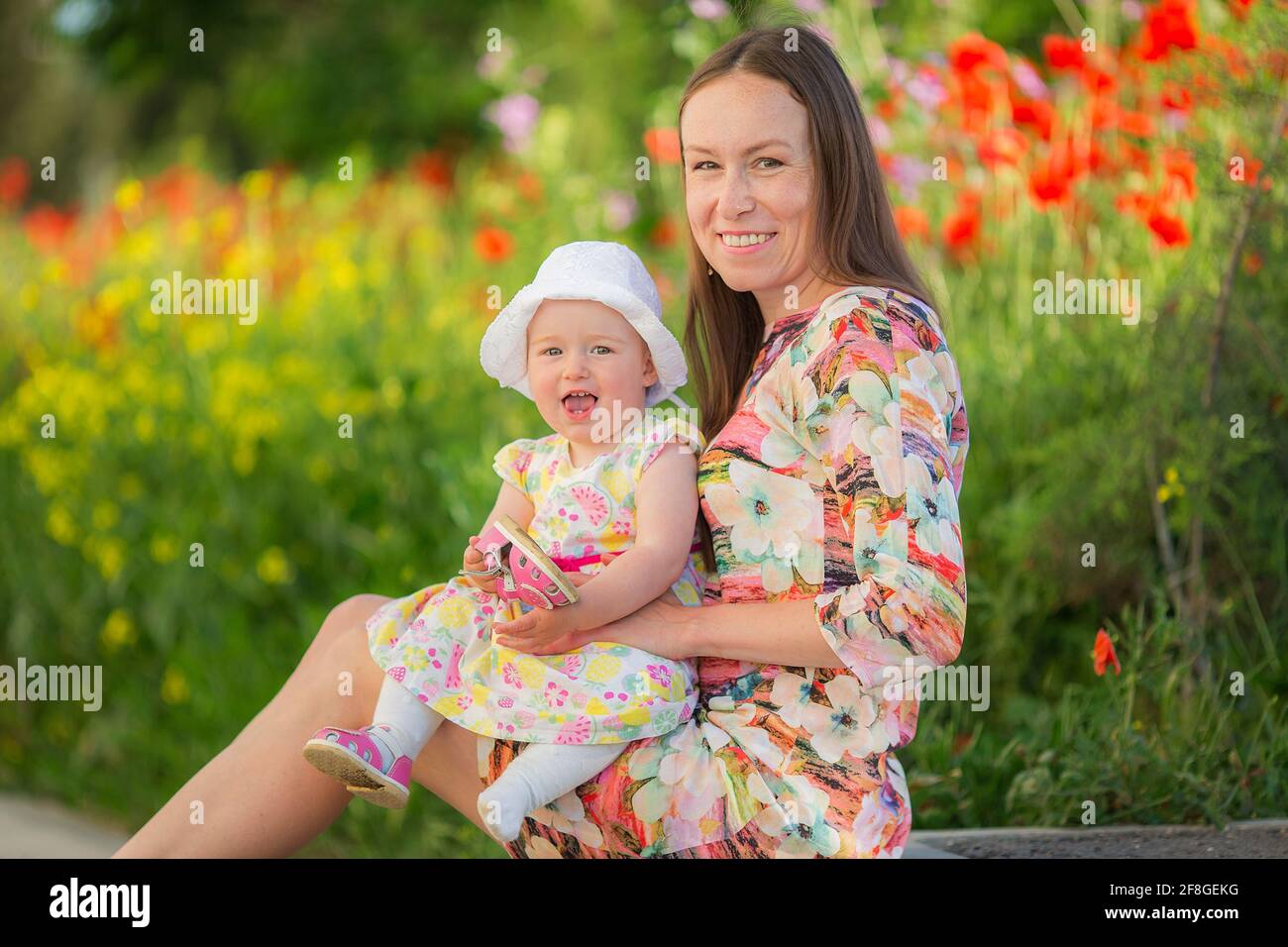 Happy woman and child on the poppy meadow. Stock Photo