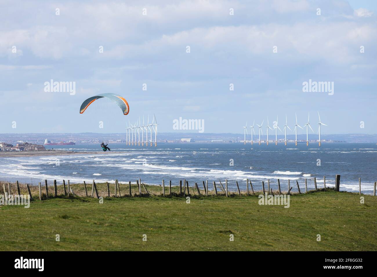 Paraglider with the Teesside Offshore Windfarm Beyond, Redcar, North Yorkshire, UK Stock Photo
