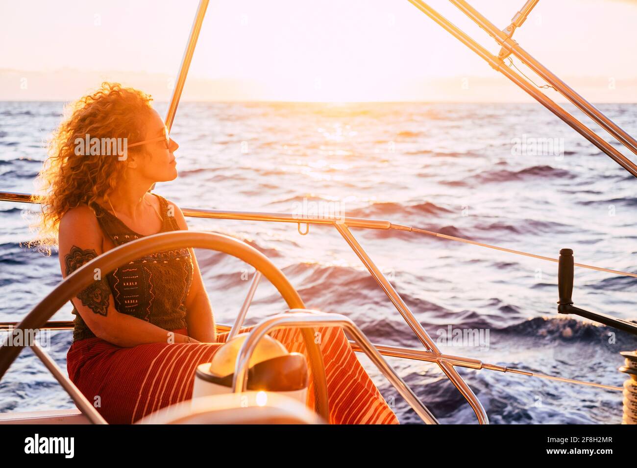 Woman traveling by boat at sunset among the oceans - happy and free ...