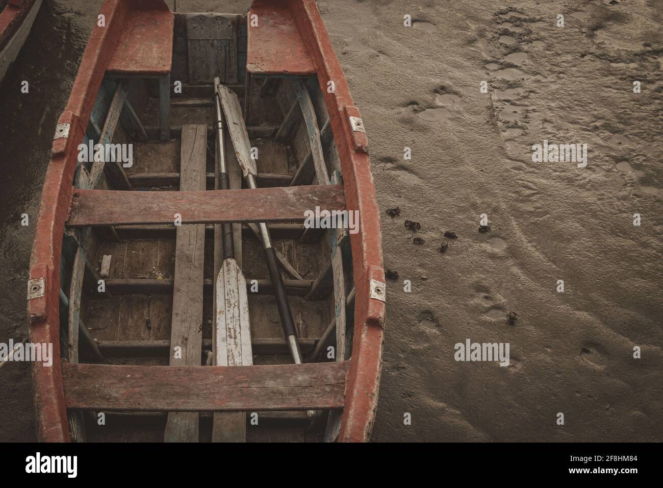 BAHIA BLANCA, ARGENTINA - Mar 08, 2020: Bote de madera, amarrado al muelle, se encuentra con marea baja en el cual se llega a apreciar cangrejos . Stock Photo