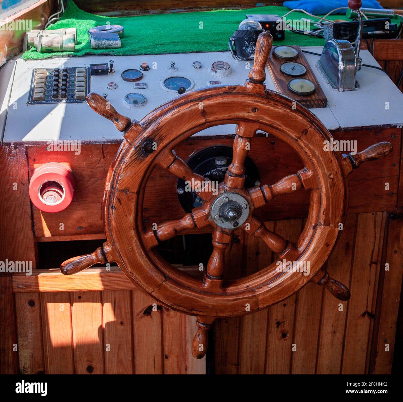 Yacht steering wheel and control panel. Ready to sea travel. Wooden deck interior of sailing boat. Ship on pier. Good weather to sail. Demre, Turkey - Stock Photo