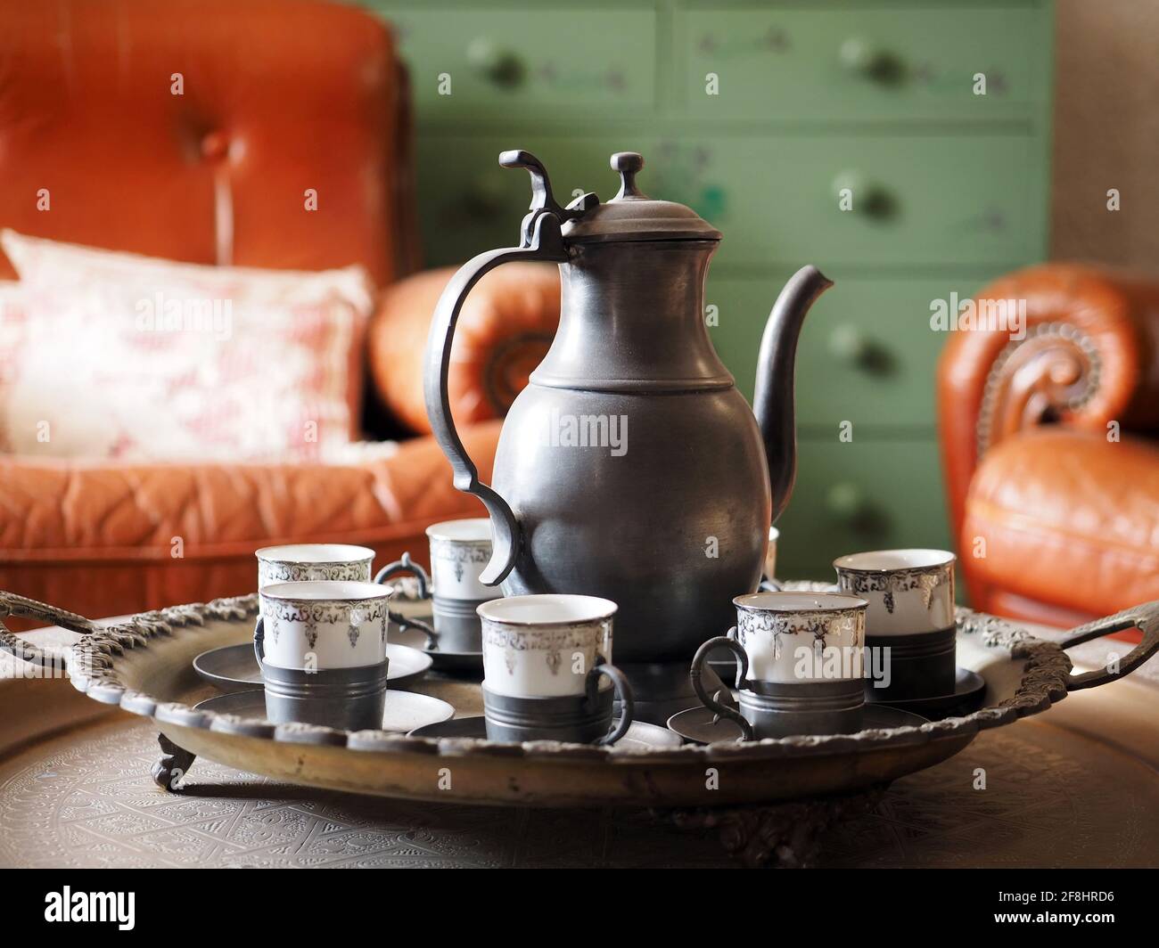 Vintage metal teapot (kettle) with many coffee/tea cups Stock Photo