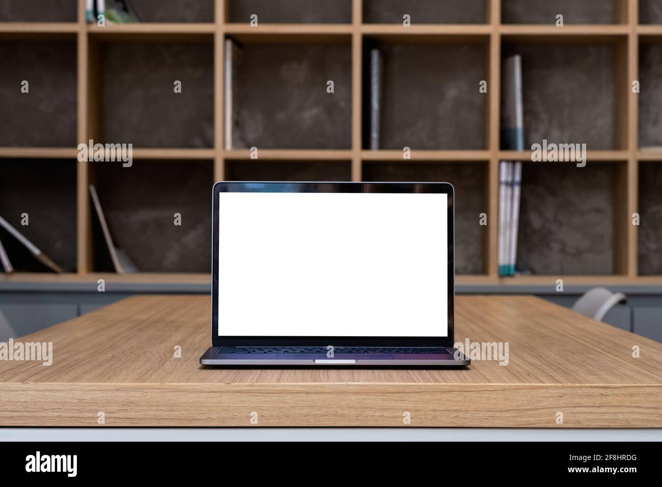 Laptop with blank screen on table in library room Stock Photo
