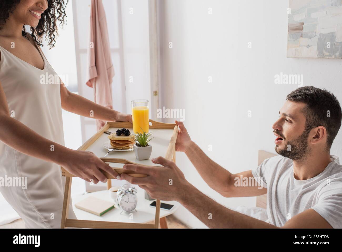 happy african american woman giving tray with breakfast to cheerful ...