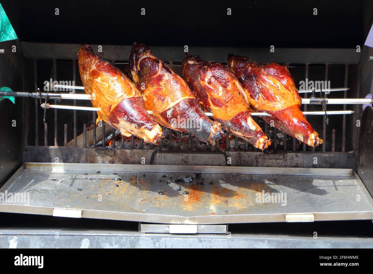Four hams roasted on a spit near a wood fire Stock Photo Alamy
