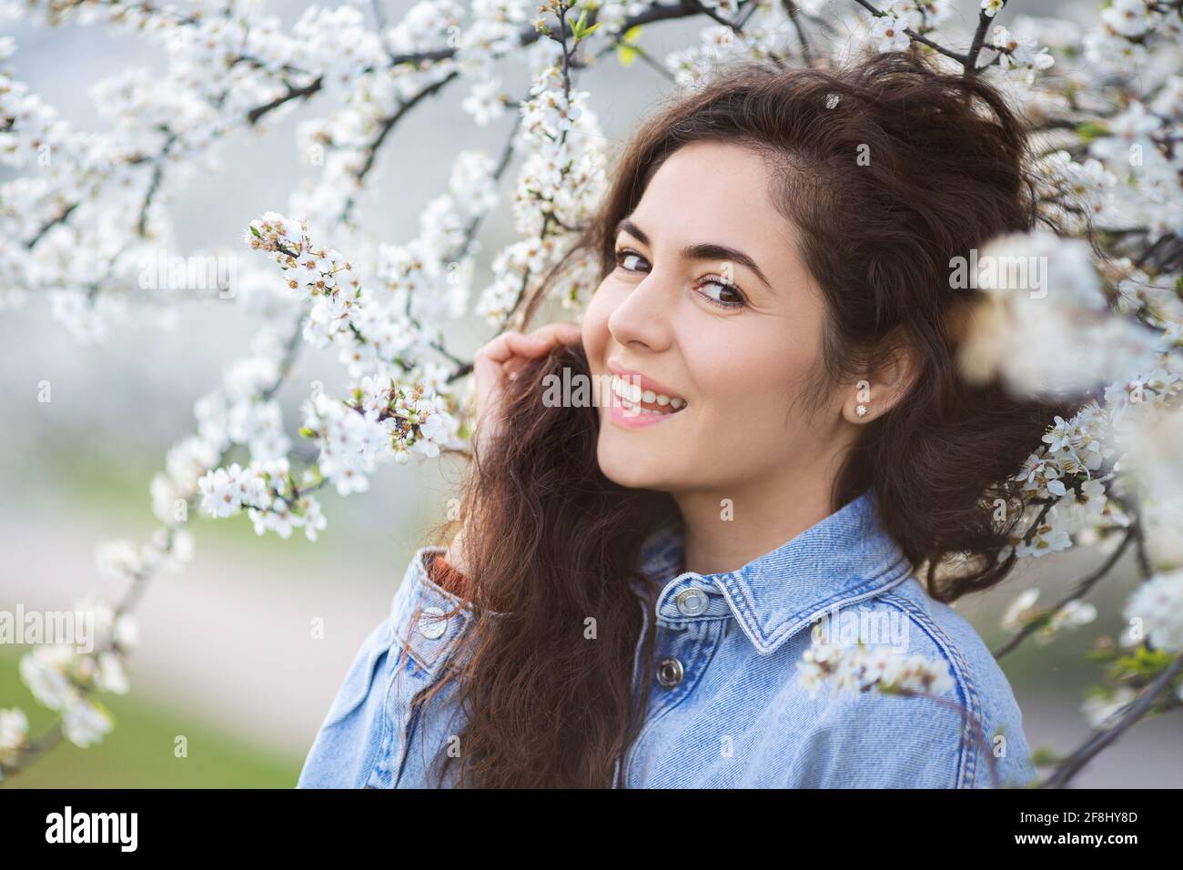 Beautiful happy girl with spring flowers. Portrait of young smiling ...