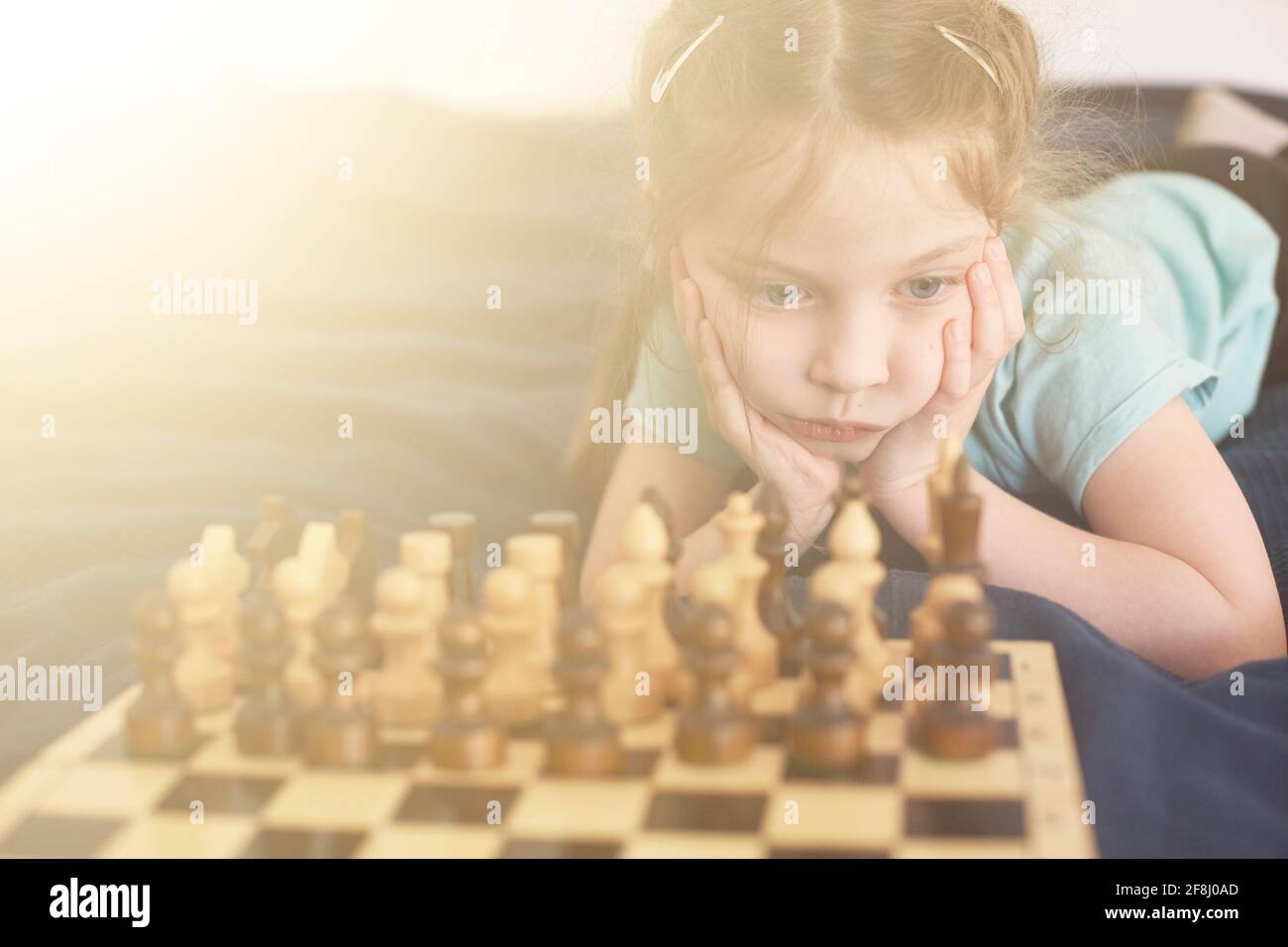 little life style girl 5 years old plays chess, development of logical thinking in children, high iq in girls. Stock Photo