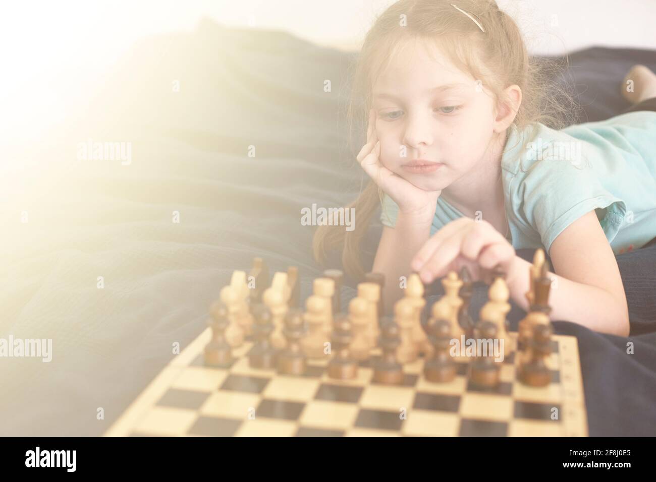 little life style girl 5 years old plays chess, development of logical thinking in children, high iq in girls. Stock Photo