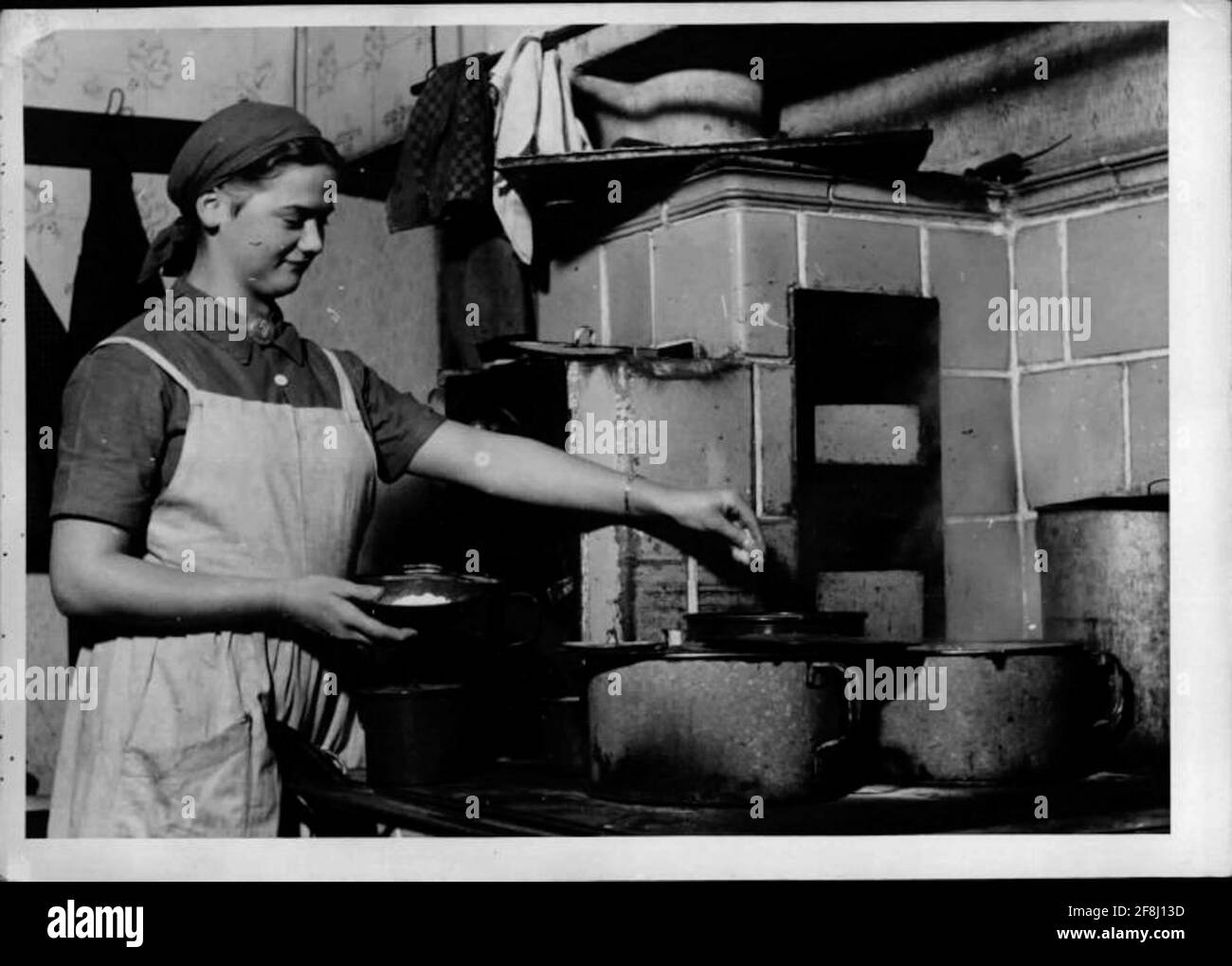 When cooking young woman at stove while cooking Stock Photo - Alamy