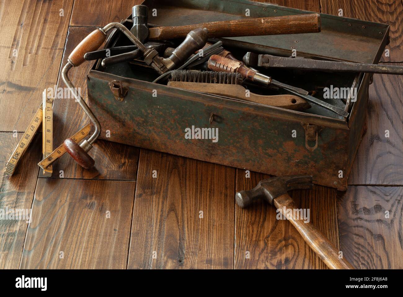 Antique tools and grungy toolbox on dark rough wood surface Stock Photo