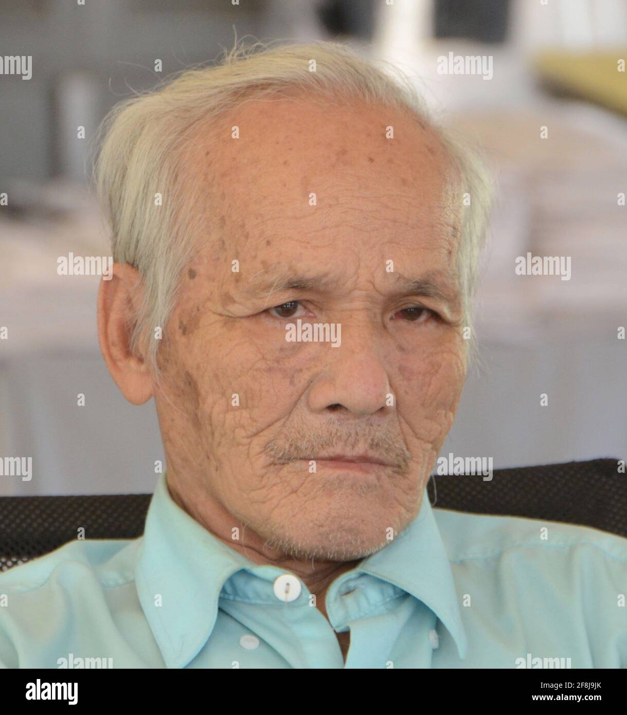 Phnom Penh, Cambodia. 13th Feb, 2017. Vice Media has admitted to digitally altering photos of prisoners held by the Khmer Rouge at the infamous Tuol Sleng or S-21 prison in Phnom Penh, Cambodia. Some of the photos were colorized by Vice and edited to show victims smiling. BOU MENG, a survivor of the prison, a former high school, is shown Tuesday, February 13, 2017, signing books for visitors to the site. Credit: Mark Hertzberg/ZUMA Wire/Alamy Live News Stock Photo