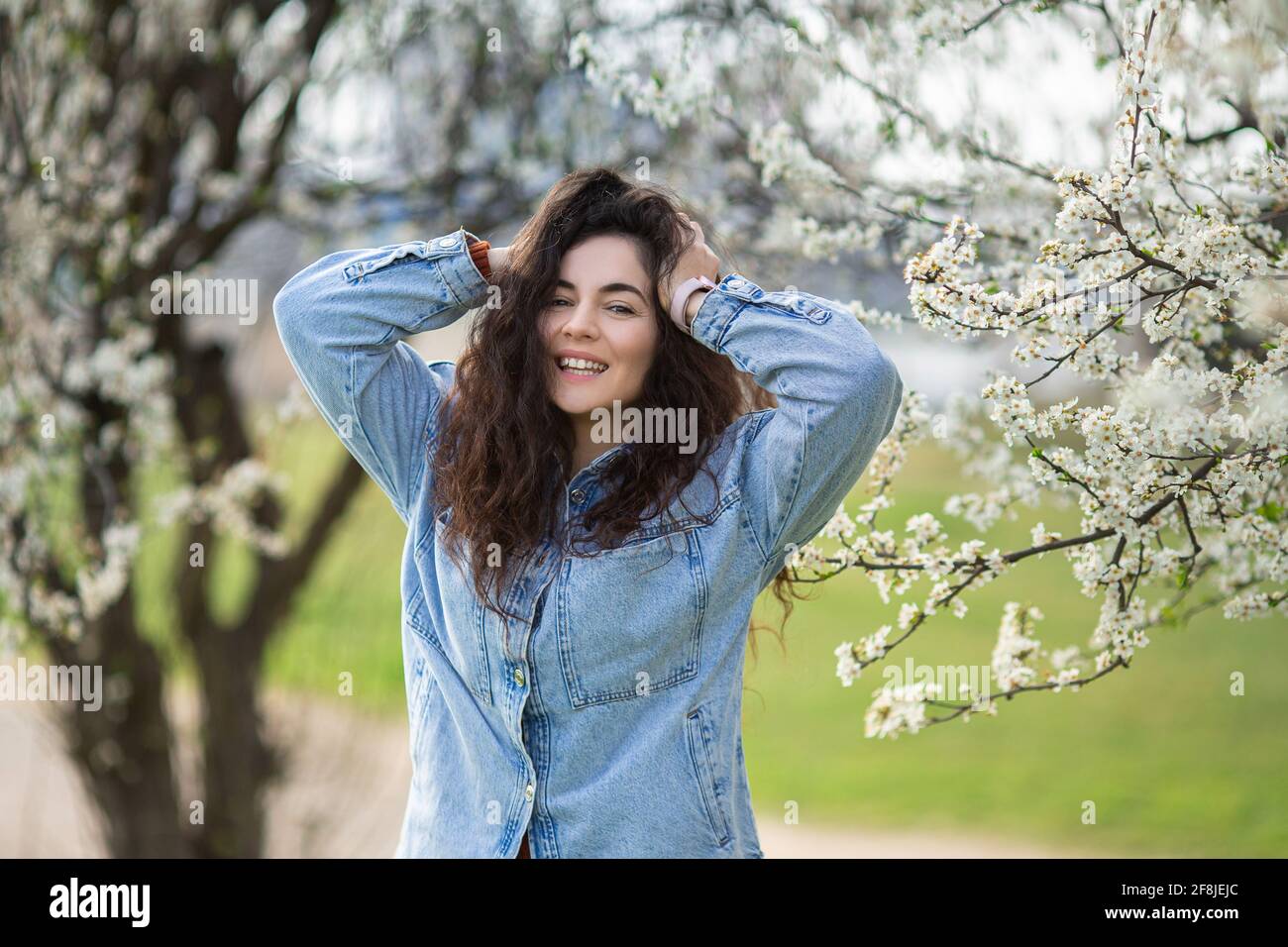 Beautiful happy girl with spring flowers. Portrait of young smiling ...