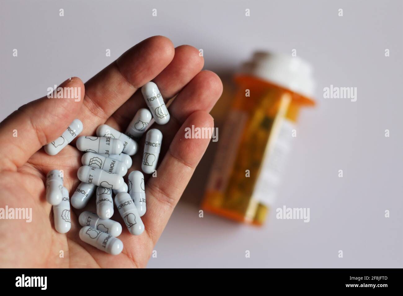 Hand with Fioricet pills. Generic names Butalbital Acetaminophen Medication used to treat tension headaches with caffeine acetaminophen and Butalbital Stock Photo
