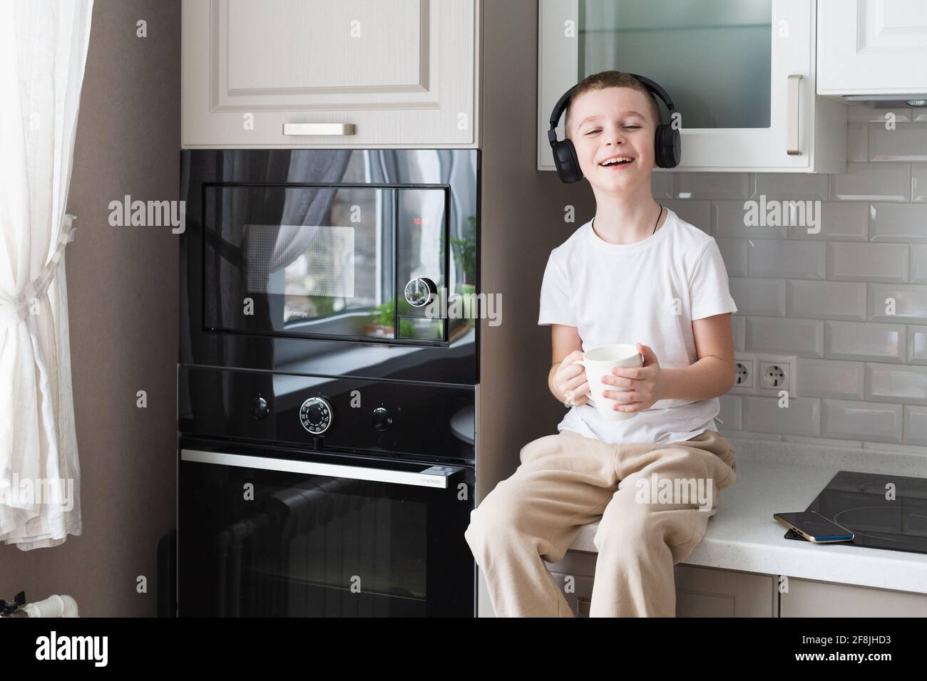 boy listening music with headphones in kitchen Stock Photo Alamy