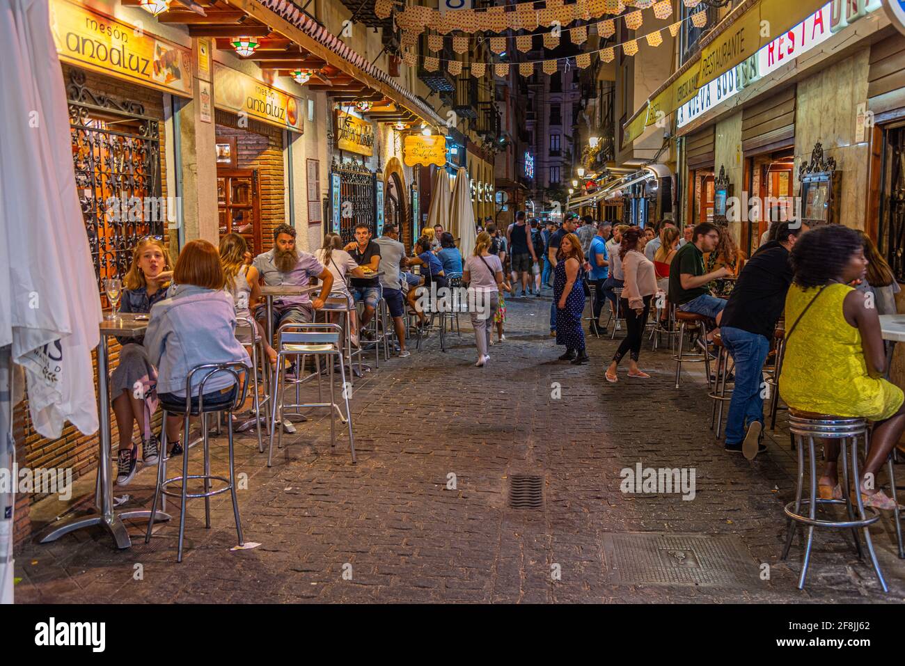 GRANADA, SPAIN, JUNE 21, 2019: Nightlife in a narrow street in Albaicin district of Granada, Spain Stock Photo