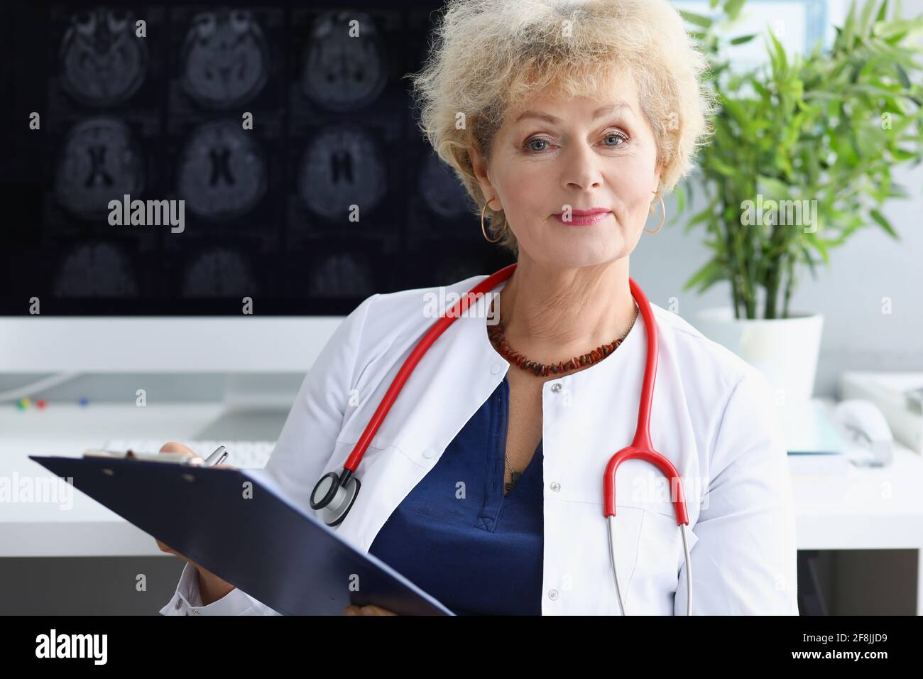 Woman doctor with stethoscope on her neck sitting with medical