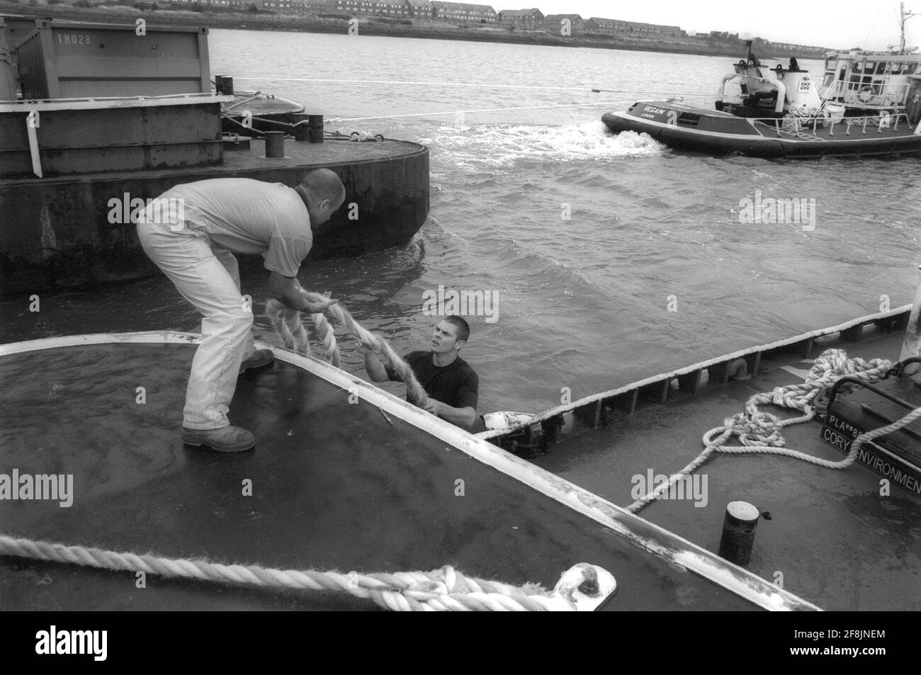 Lightermen of the River Thames using ropes to secure the barges for towing Stock Photo