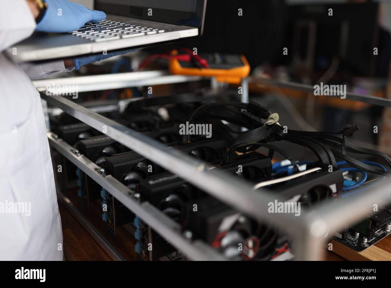 Master checking cryptocurrency mining rig using graphic cards closeup Stock Photo