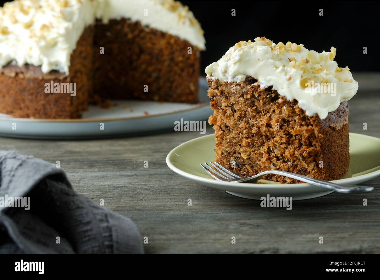 A home baked gluten free carrot and walnut cake. This moist cake has an indulgent cream cheese topping and was made with gluten free ingredients Stock Photo