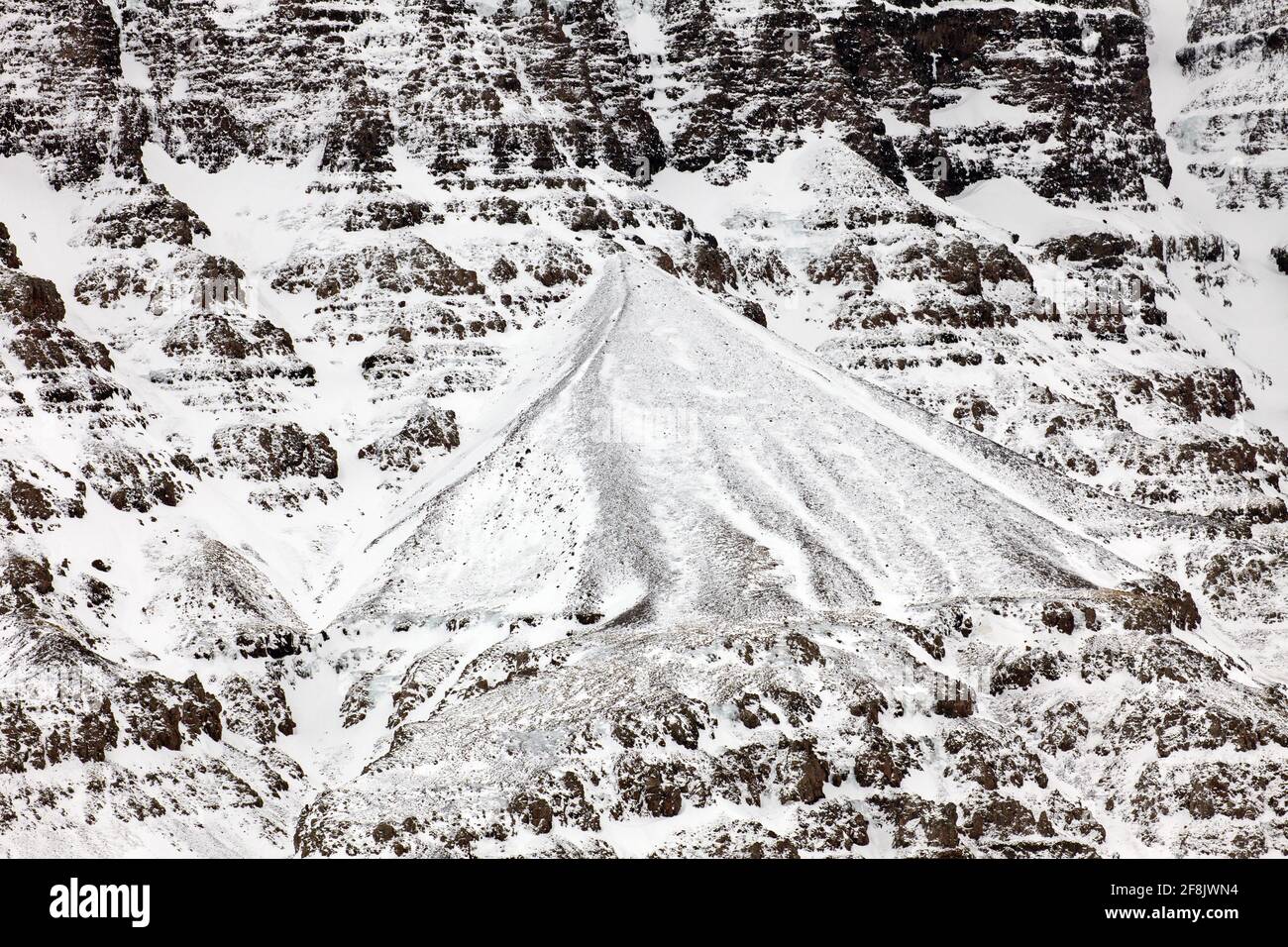 Snow covered talus cone and scree, stony deposit at base of mountain slope in winter at Snaefellsnes, western Iceland Stock Photo