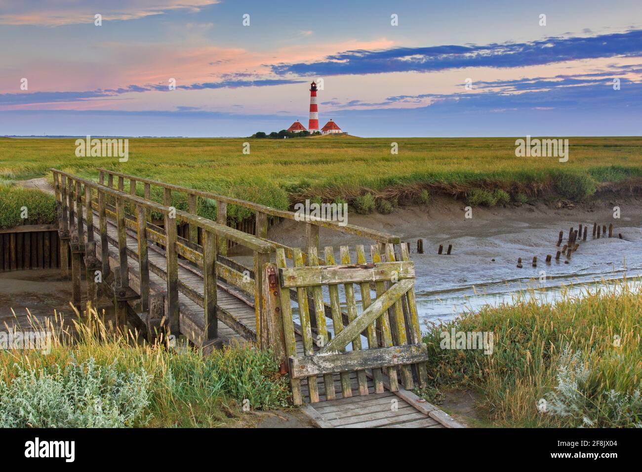 Wooden footbridge and lighthouse Westerheversand at Westerhever, Peninsula of Eiderstedt, Wadden Sea National Park, North Frisia, Germany Stock Photo