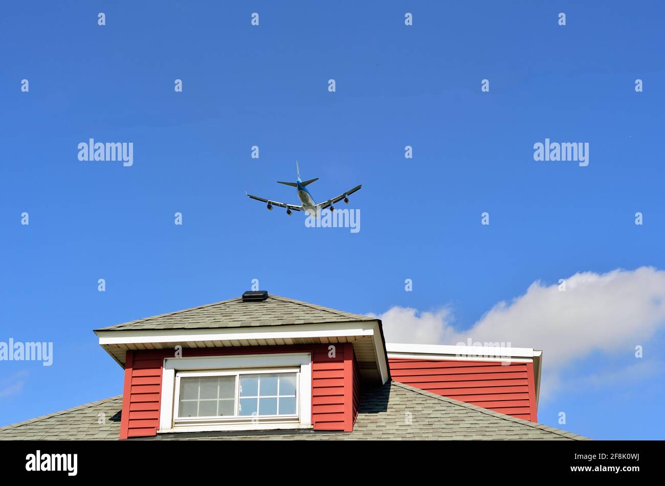 Schiller Park, Illinois, USA. A KLM jumbo jet taking off for a trans-Atlantic flight from Chicago's O'Hare International Airport ascends above a home. Stock Photo