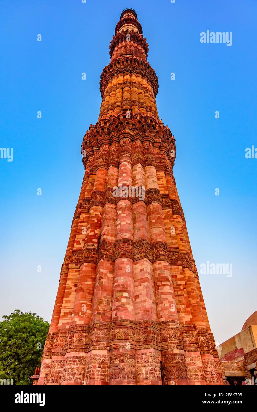 Qutub Minar is a highest minaret in India standing 73 m tall tapering tower of five storeys made of red sandstone and marble established in 1192. Stock Photo