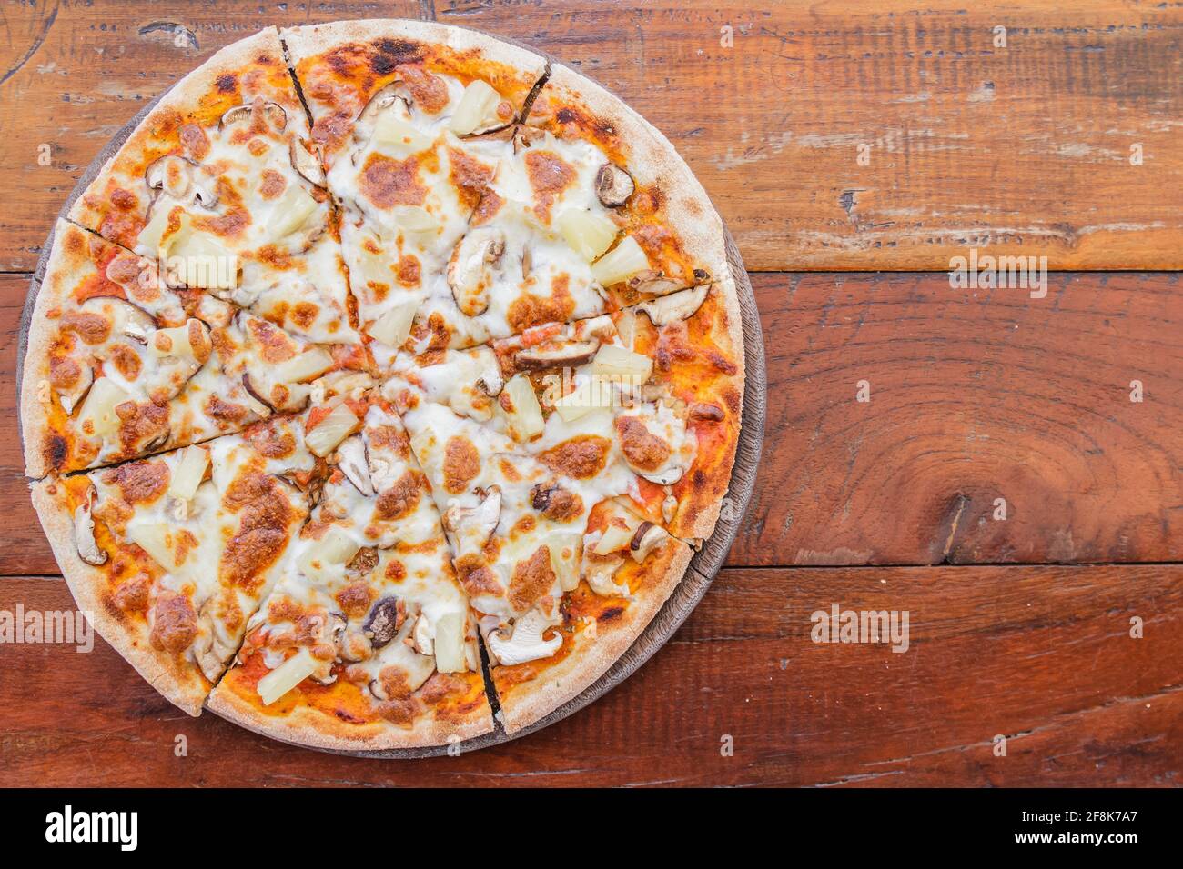 Pizza vegetarian with mushroom and pineapple on wood table in