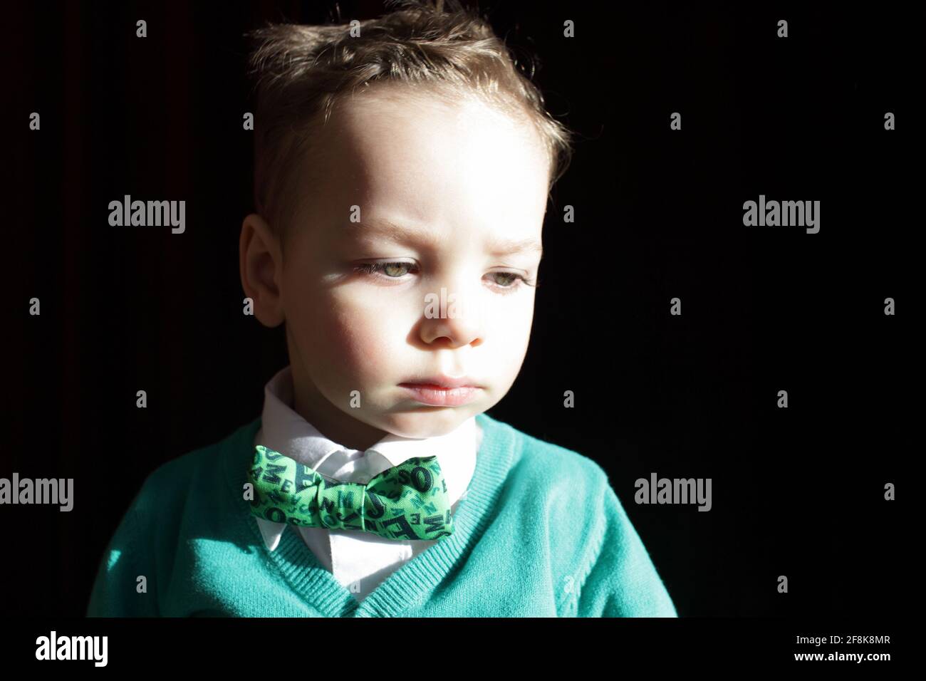 Kid in a green cardigan with white shirt and bow tie Stock Photo Alamy