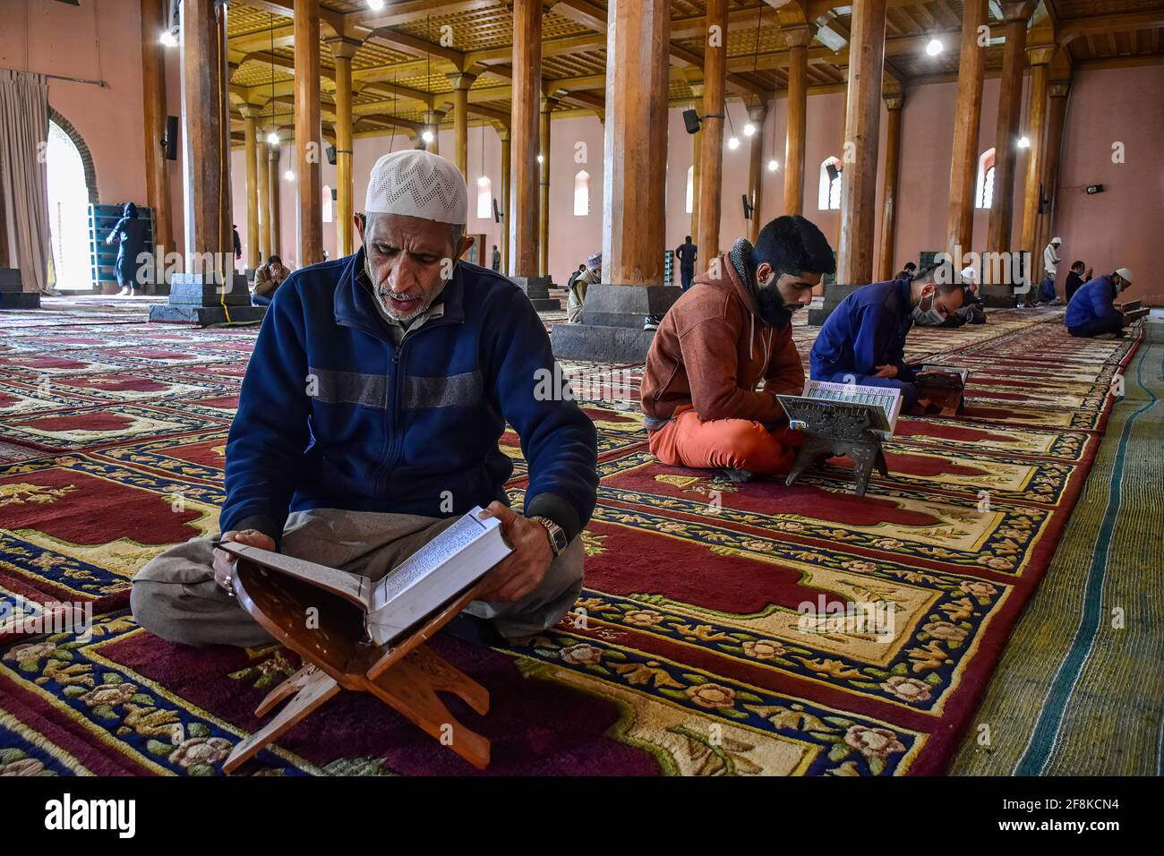 Srinagar, India. 14th Apr, 2021. Kashmiri men recite the Holy Quran ...