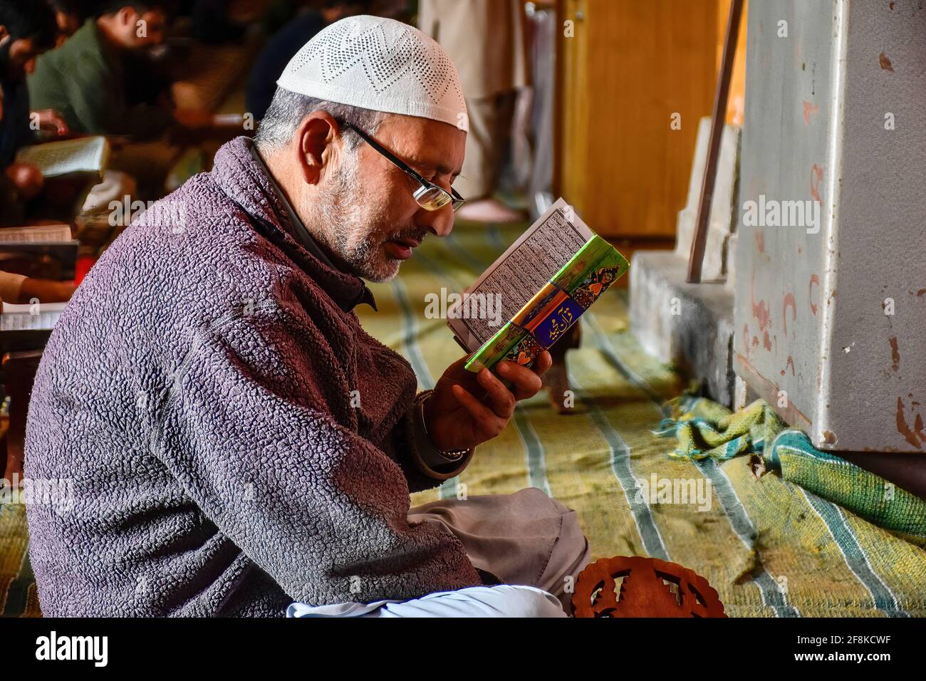Srinagar, India. 14th Apr, 2021. A Kashmiri man recites the Holy Quran ...
