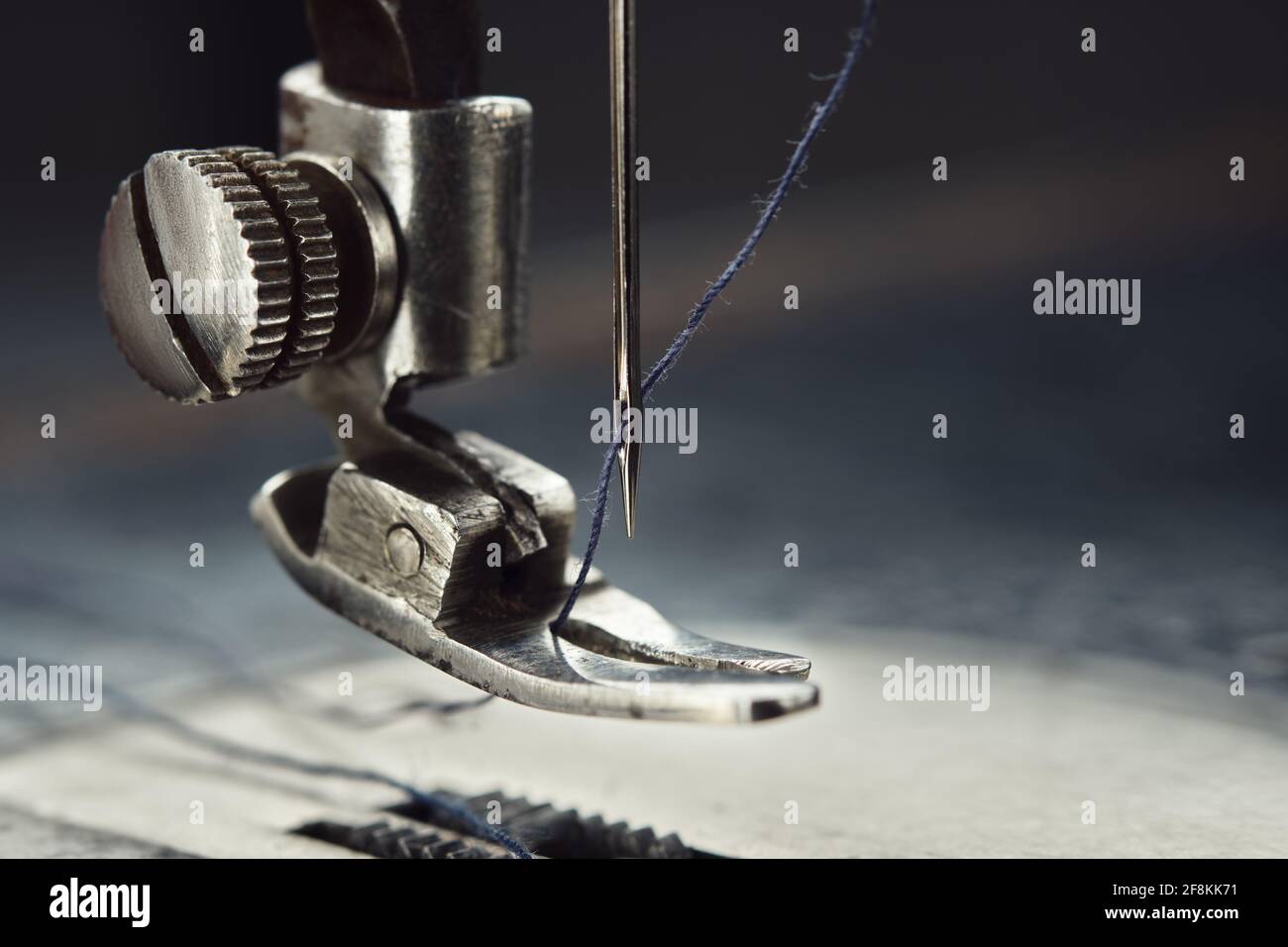 Close up of sewing machine needle with thread. Working part of antique sewing machine. Stock Photo