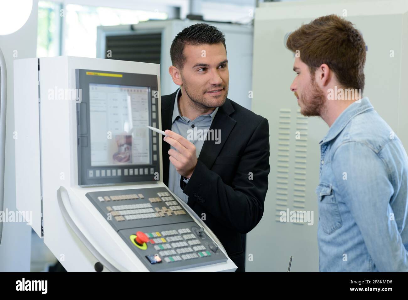 engineer showing apprentice how to measure cad drawings Stock Photo