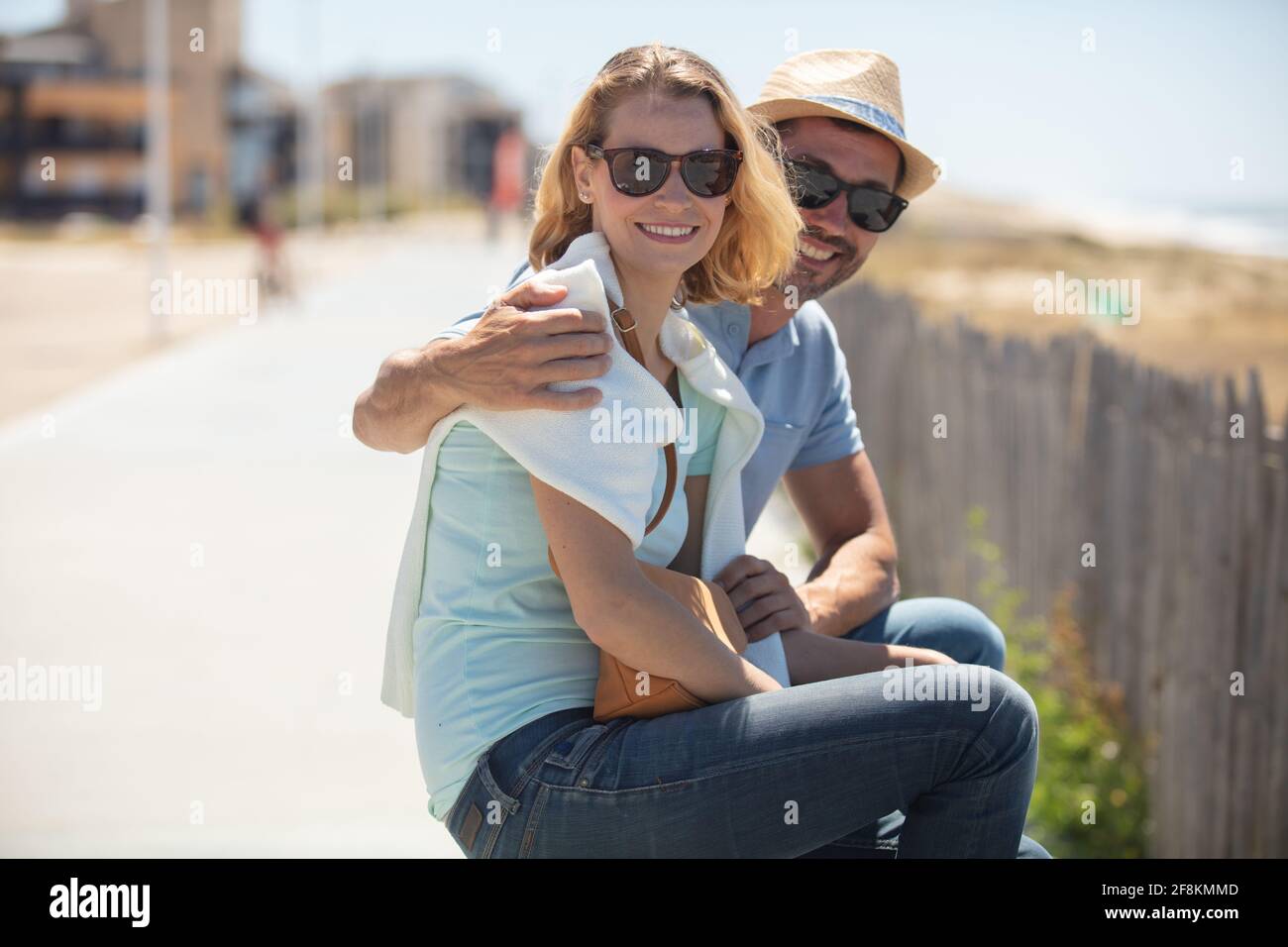 couple sitting on bench together at the beach in love Stock Photo - Alamy
