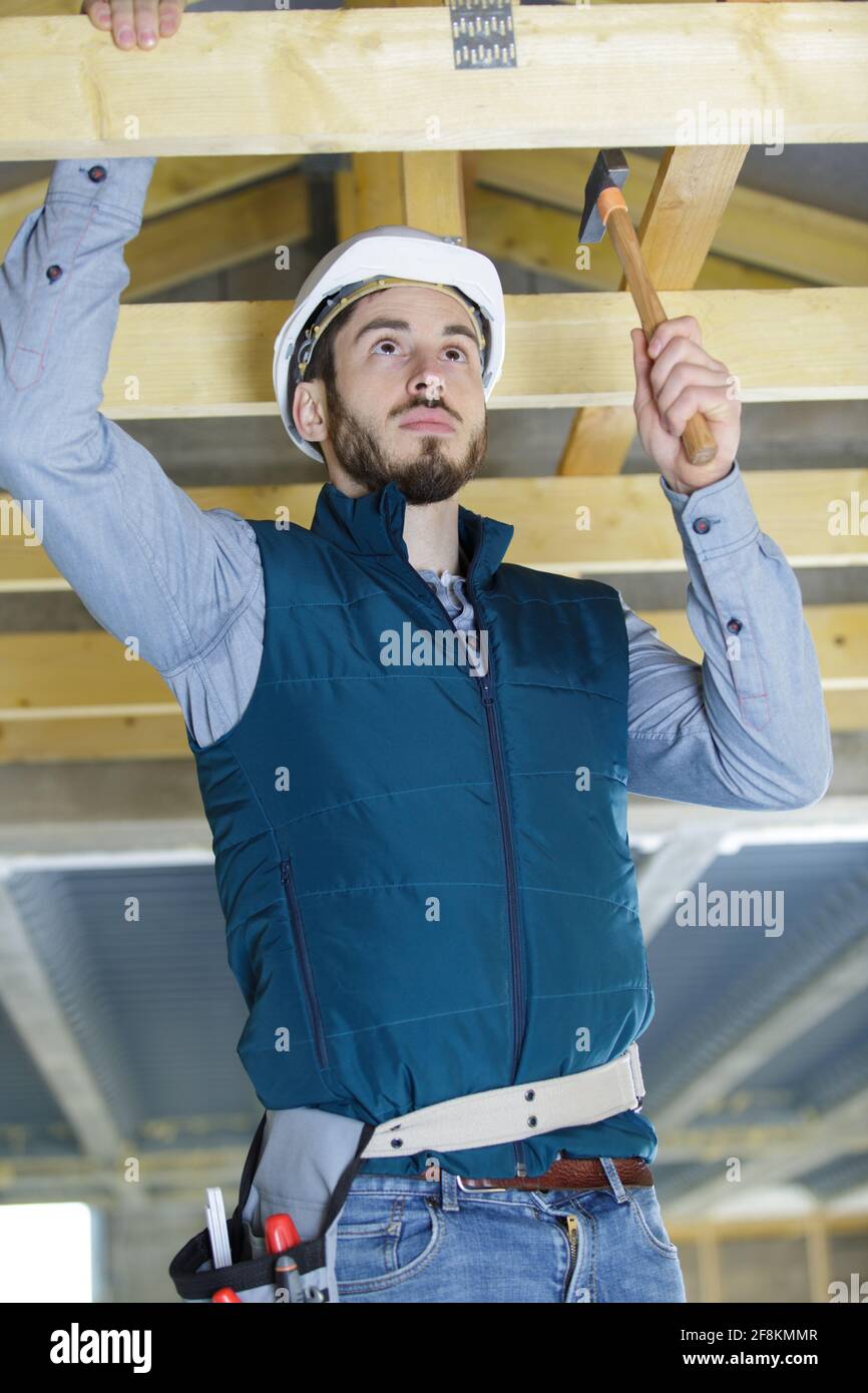roofer builder working on roof structure Stock Photo