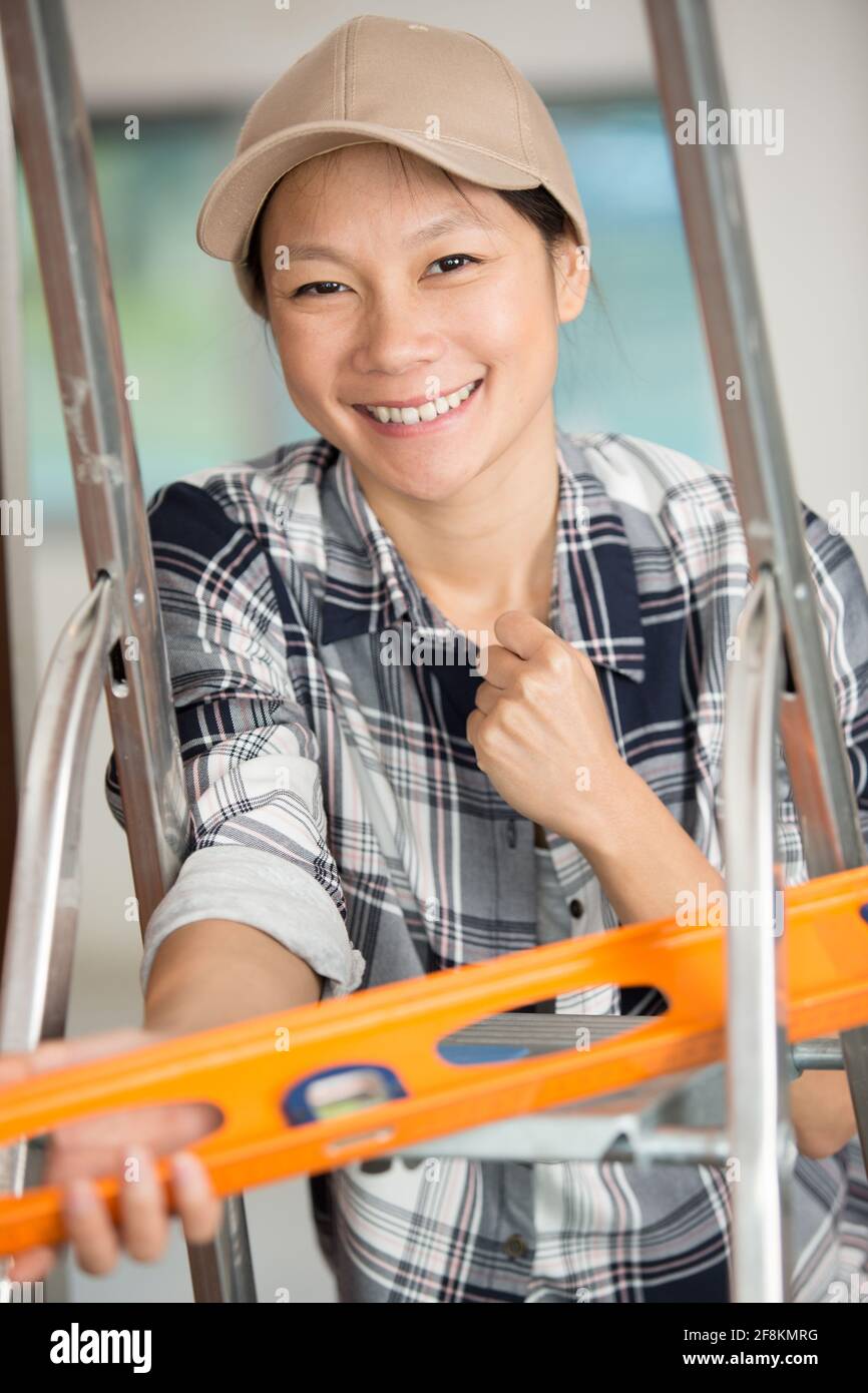 smiling female worker using a spirit level Stock Photo