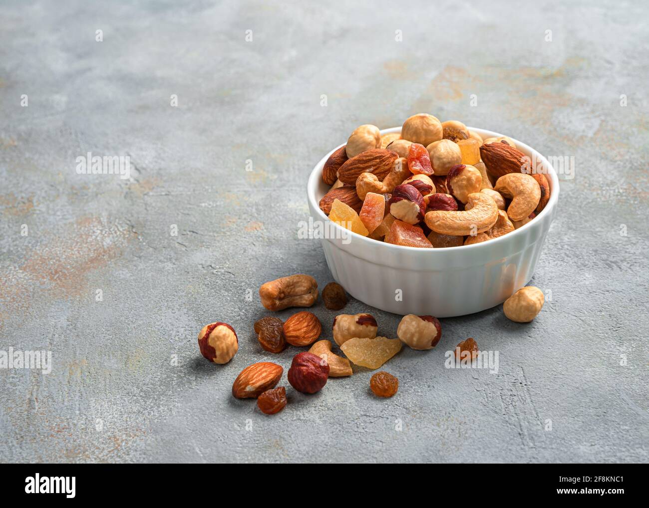 Healthy snack: a mixture of dried fruits and different types of nuts on a gray background. Side view, close-up, copy space. Stock Photo