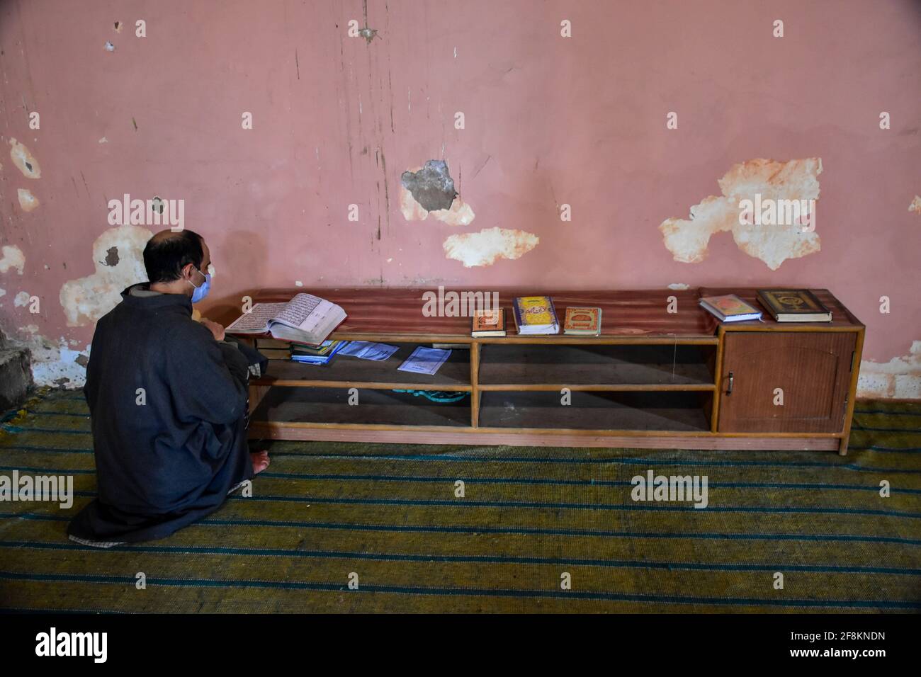 Srinagar, India. 14th Apr, 2021. A Kashmiri man recites the Holy Quran ...